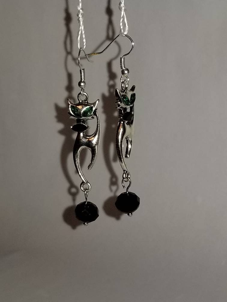 Charming 1950's Siamese Cat earrings. These silver dangly earrings feature green eyes & black bowtie on an iconic vintage siamese cat.